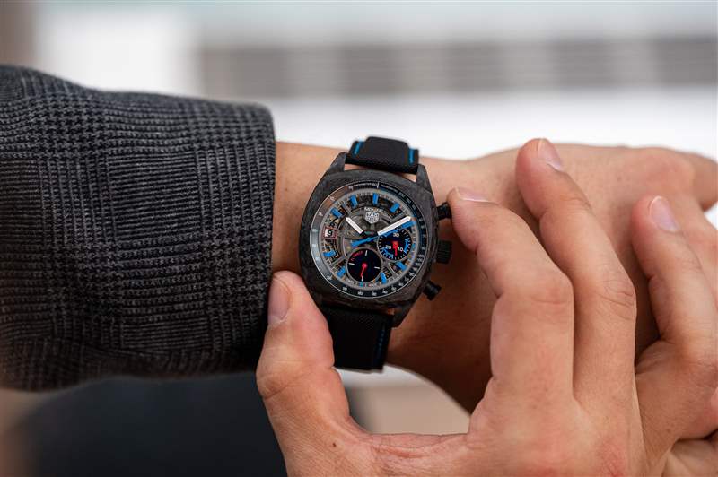 TAG Heuer Monza 鏤空表盤，佩戴在手腕上并推動手表上的按鈕。